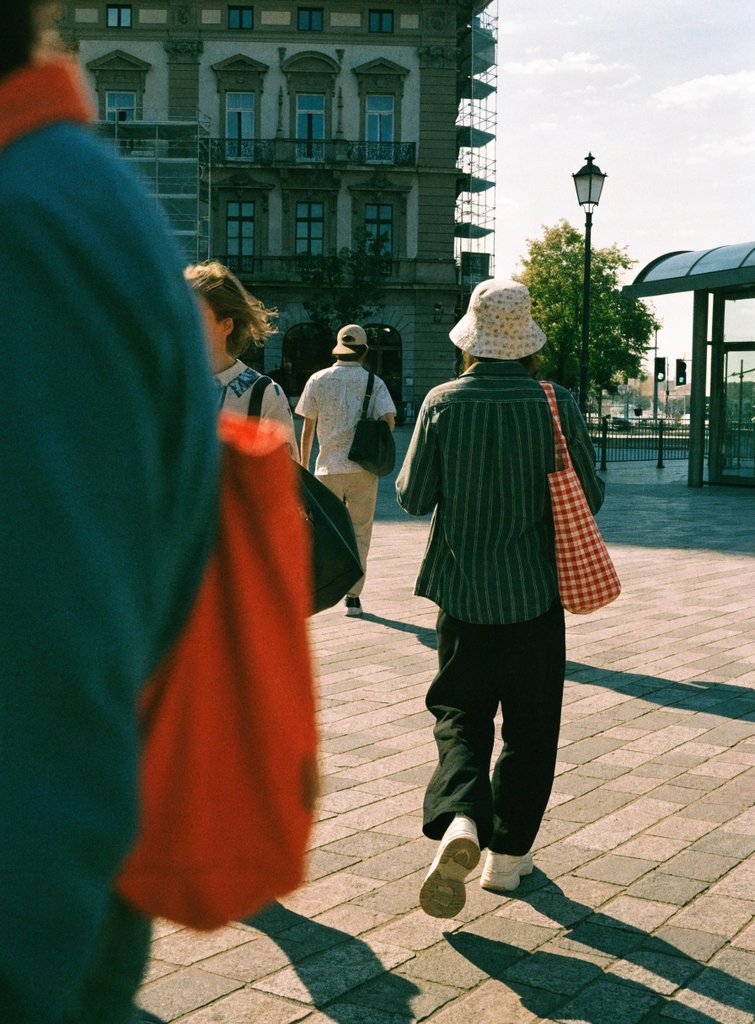 People walking a sunlit street at golden hour